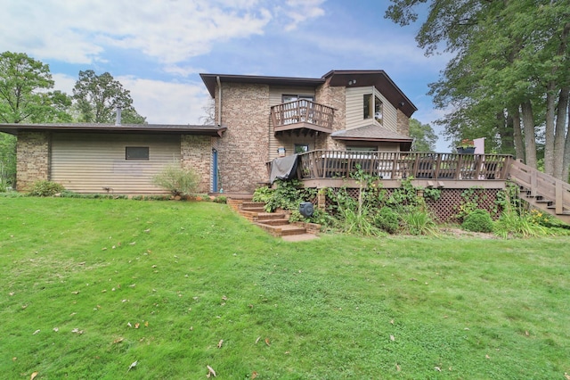 rear view of house featuring a lawn, a deck, a balcony, and brick siding