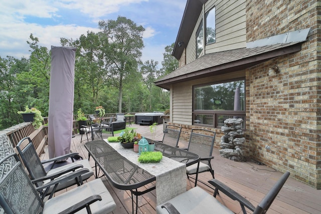 wooden deck with outdoor dining space and a hot tub