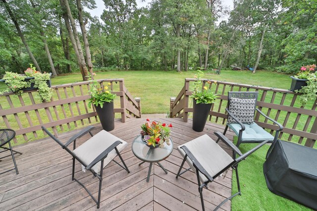 wooden terrace featuring a yard