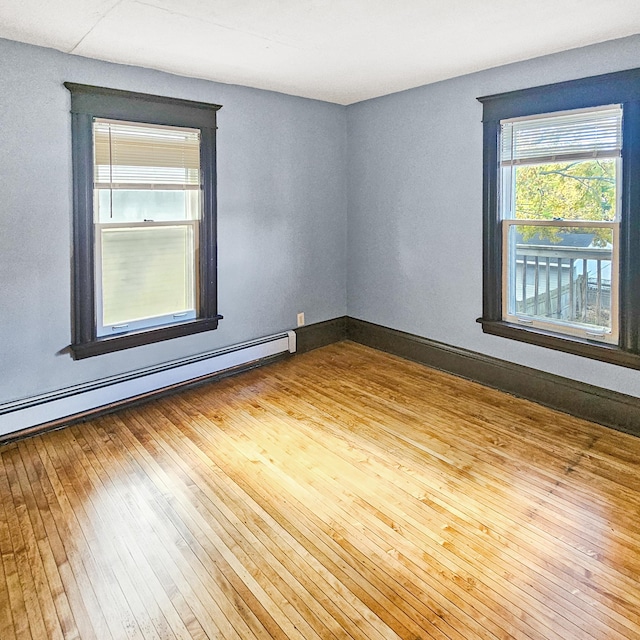 unfurnished room with light hardwood / wood-style floors and a baseboard radiator