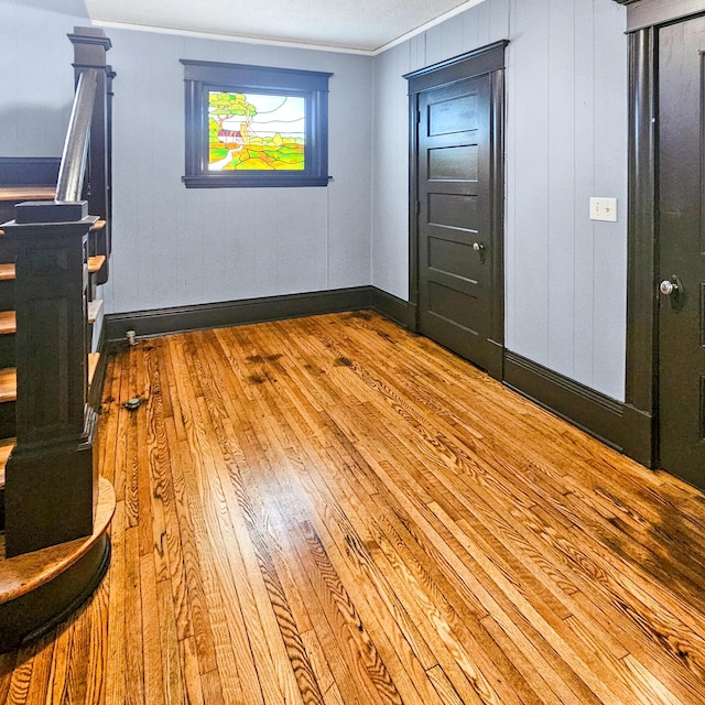 interior space with light wood-type flooring and crown molding