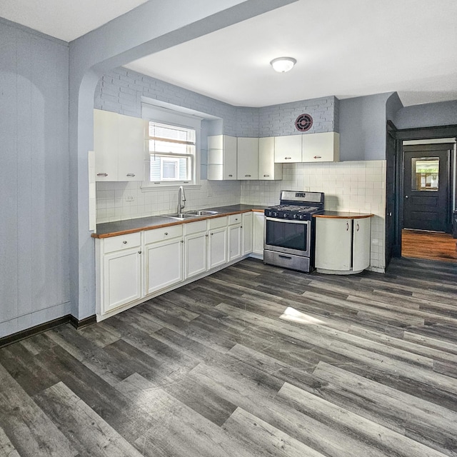 kitchen with backsplash, white cabinets, stainless steel range with gas cooktop, sink, and dark hardwood / wood-style floors