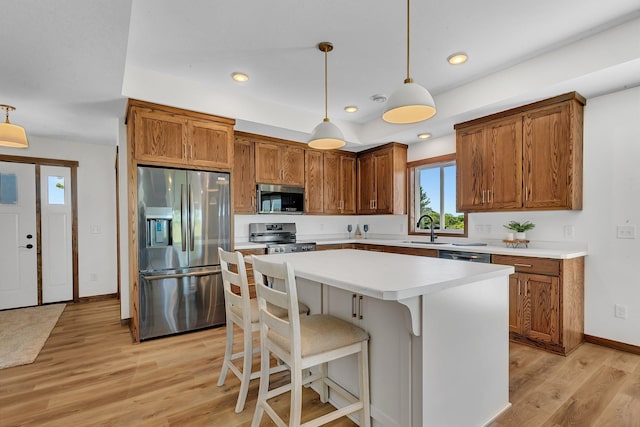 kitchen featuring pendant lighting, a center island, stainless steel appliances, and light hardwood / wood-style flooring