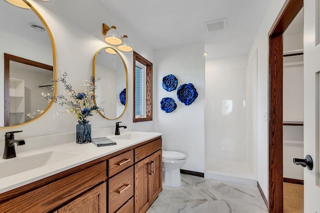 bathroom featuring vanity, toilet, and a shower