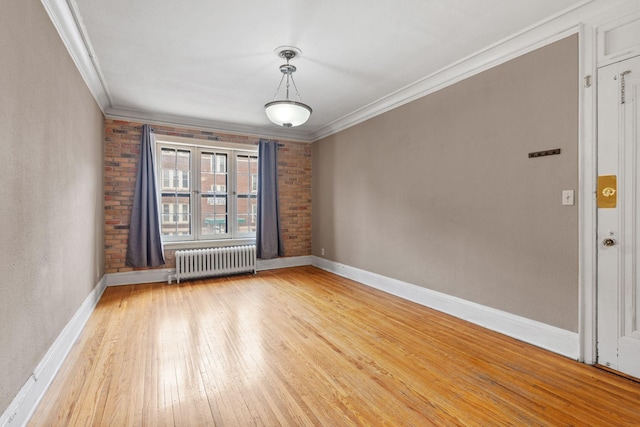 unfurnished room featuring ornamental molding, wood-type flooring, and radiator