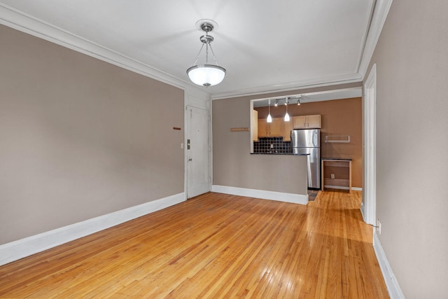 unfurnished living room with crown molding and light hardwood / wood-style flooring