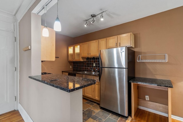 kitchen with kitchen peninsula, dark hardwood / wood-style floors, decorative light fixtures, and stainless steel refrigerator