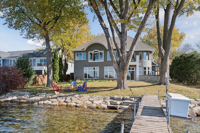 view of dock with a yard and a water view