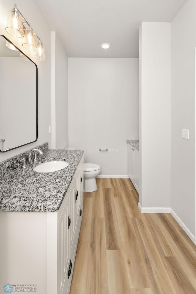 bathroom with vanity, hardwood / wood-style floors, and toilet