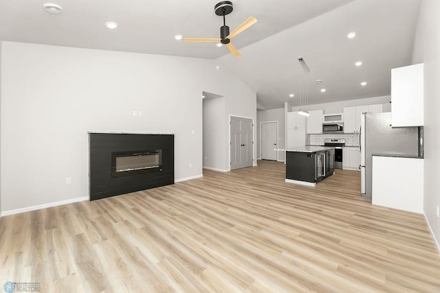 kitchen featuring appliances with stainless steel finishes, a center island, light hardwood / wood-style flooring, and white cabinetry