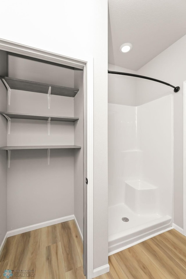 bathroom featuring hardwood / wood-style floors and a shower