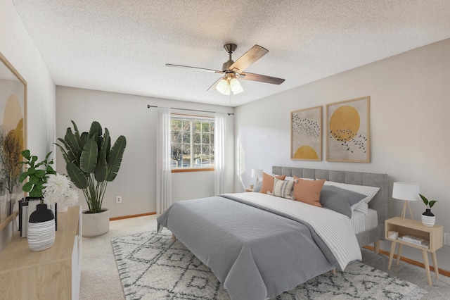 carpeted bedroom featuring ceiling fan and a textured ceiling