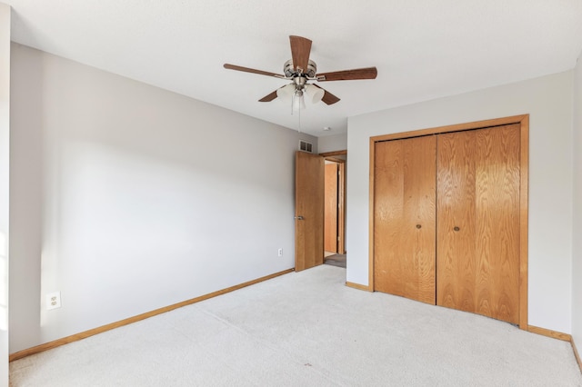 unfurnished bedroom with ceiling fan, a closet, and light carpet