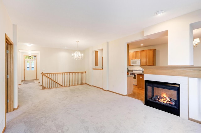 unfurnished living room featuring a multi sided fireplace, light colored carpet, and a notable chandelier