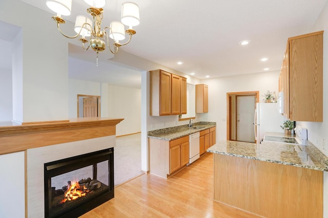 kitchen featuring sink, kitchen peninsula, decorative light fixtures, and white appliances