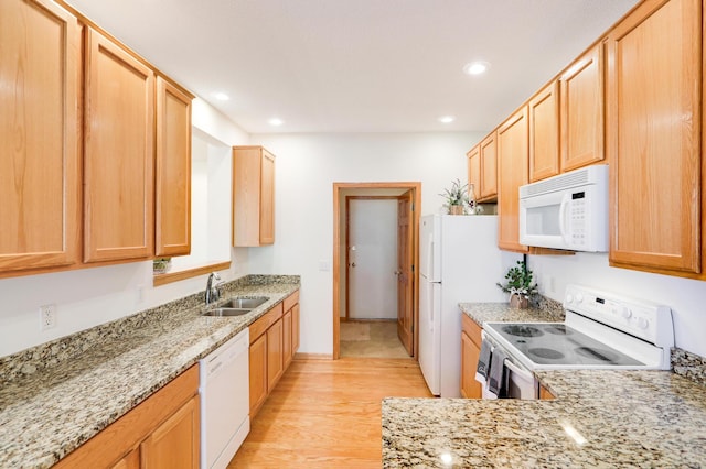 kitchen featuring white appliances, light hardwood / wood-style floors, light stone countertops, and sink