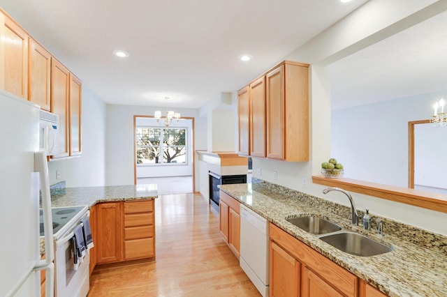 kitchen featuring light hardwood / wood-style flooring, sink, an inviting chandelier, light stone counters, and white appliances