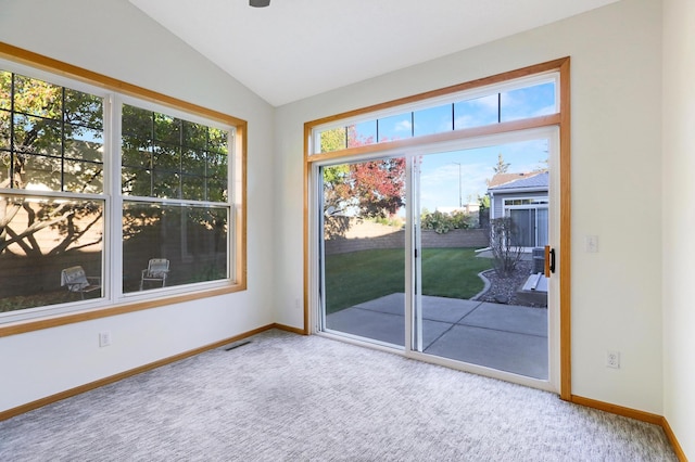 entryway featuring vaulted ceiling, carpet floors, and a healthy amount of sunlight