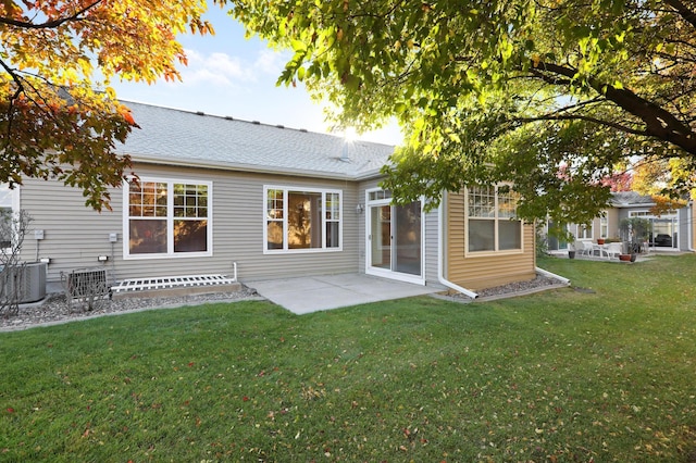 rear view of property featuring central air condition unit, a patio area, and a lawn