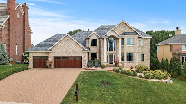 view of front of home with cooling unit, a garage, and a front lawn