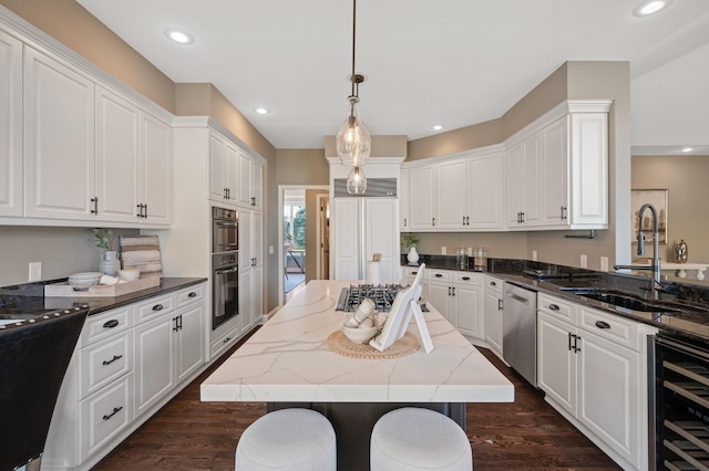 kitchen with dark hardwood / wood-style flooring, a kitchen island, white cabinetry, pendant lighting, and sink