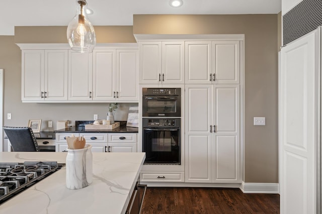 kitchen with light stone countertops, black appliances, dark hardwood / wood-style flooring, white cabinetry, and pendant lighting