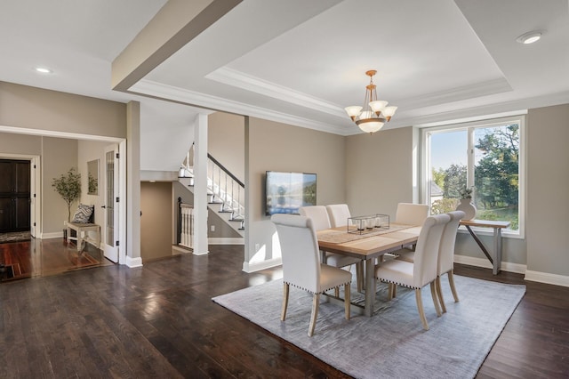 dining space with crown molding, a raised ceiling, an inviting chandelier, and dark hardwood / wood-style floors