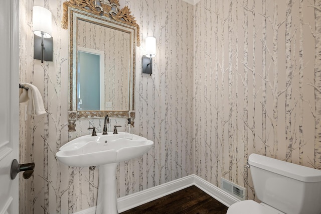 bathroom with hardwood / wood-style flooring and toilet