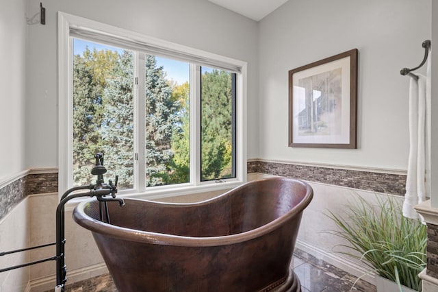 bathroom featuring a bathing tub and a wealth of natural light