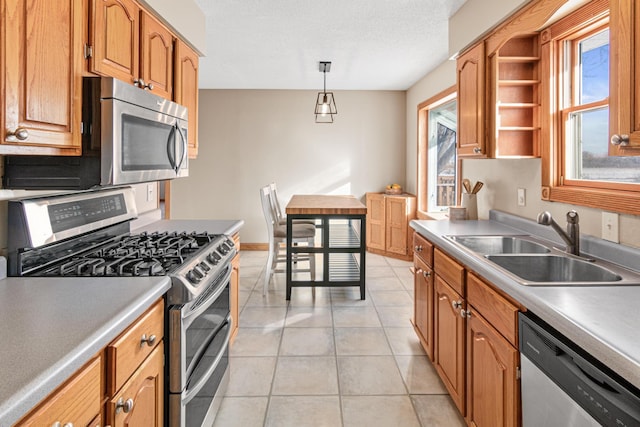 kitchen featuring sink, decorative light fixtures, a textured ceiling, light tile patterned floors, and appliances with stainless steel finishes