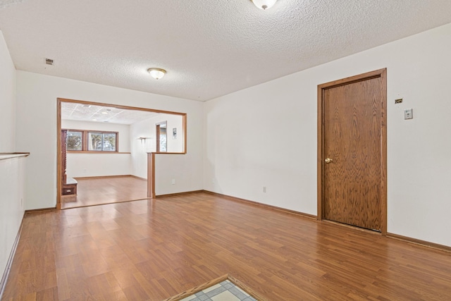 unfurnished room featuring wood-type flooring and a textured ceiling