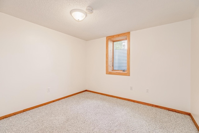 carpeted empty room featuring a textured ceiling