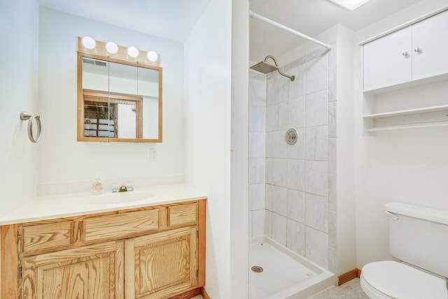 bathroom featuring vanity, toilet, and tiled shower