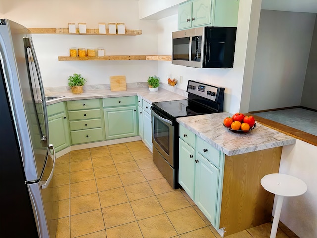 kitchen featuring green cabinets and appliances with stainless steel finishes