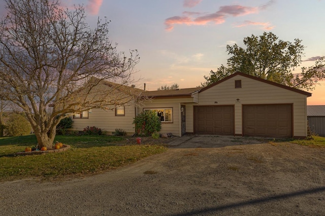 ranch-style house with a garage and a lawn