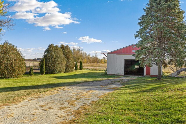 3234 14th Ave, Owatonna, MN 55060 - view of green lawn with an outbuilding, driveway, a detached garage, and an outdoor structure
