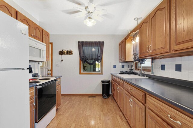 3234 14th Ave, Owatonna, MN 55060 - kitchen featuring white appliances, a sink, light wood-style flooring, a ceiling fan, and dark countertops
