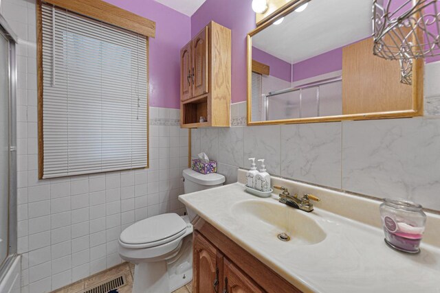 3234 14th Ave, Owatonna, MN 55060 - bathroom with toilet, vanity, tile walls, and a wainscoted wall