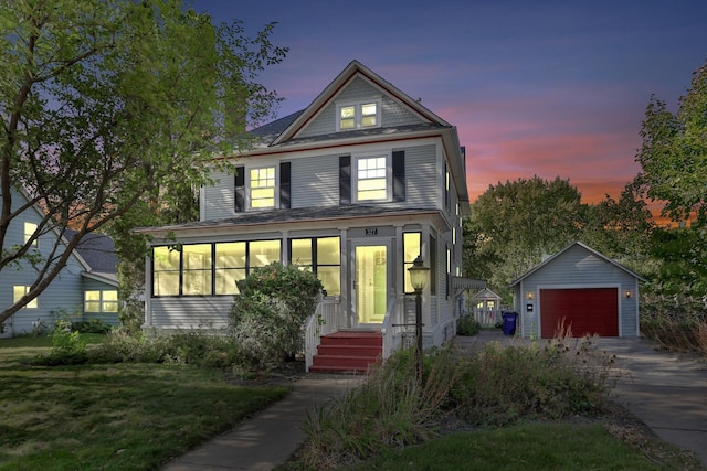 view of front facade featuring a garage, a yard, and an outbuilding