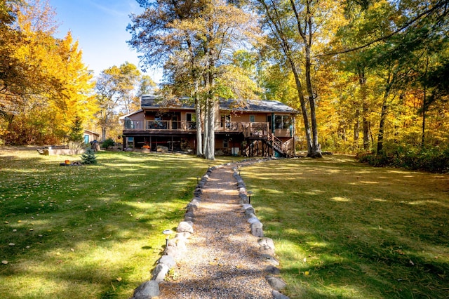 rear view of house with a yard, stairway, and a wooden deck