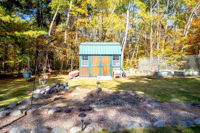 view of shed featuring fence and a view of trees