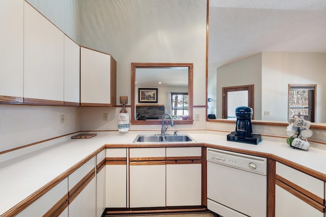 kitchen featuring light countertops, dishwasher, a sink, and white cabinetry