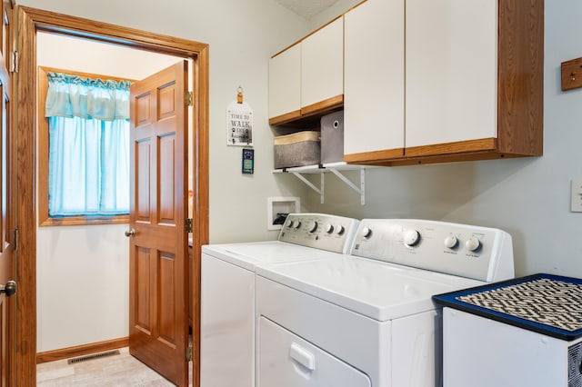 clothes washing area featuring cabinet space, visible vents, baseboards, and separate washer and dryer