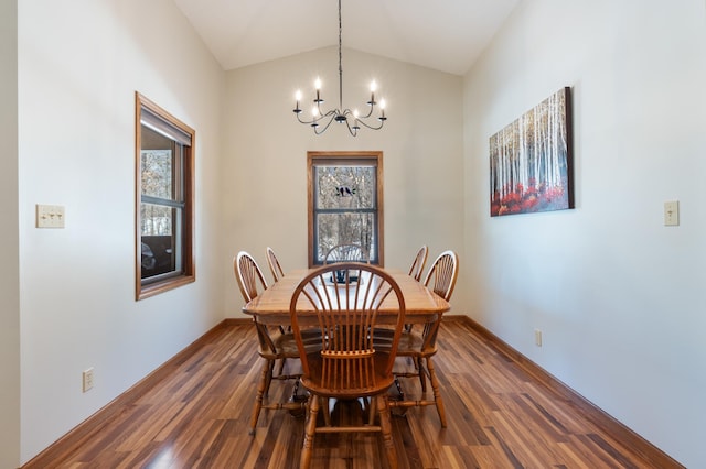 dining room with lofted ceiling, dark wood-style flooring, a chandelier, and baseboards