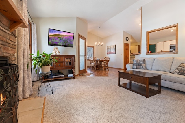 living area with baseboards, high vaulted ceiling, wood finished floors, and a notable chandelier