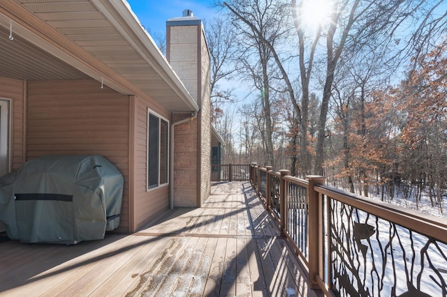 snow covered deck with a grill