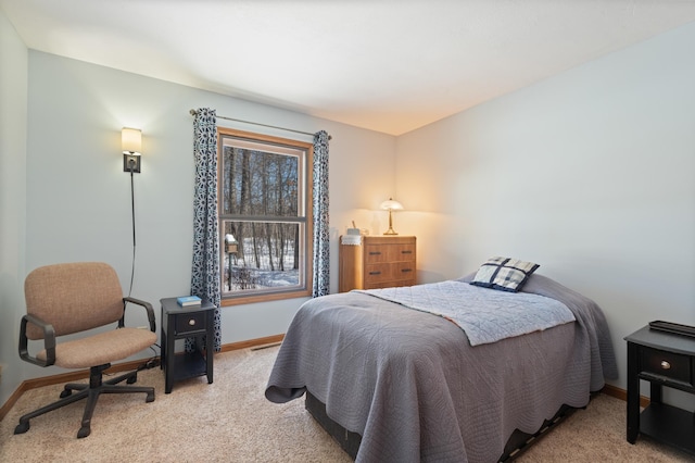 bedroom featuring light carpet and baseboards