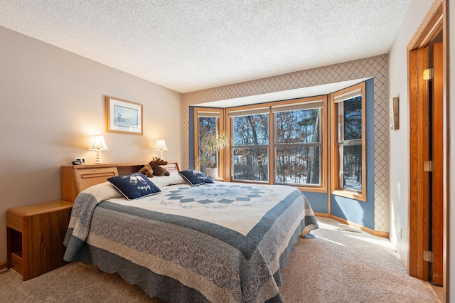 bedroom with light colored carpet, a textured ceiling, baseboards, and wallpapered walls