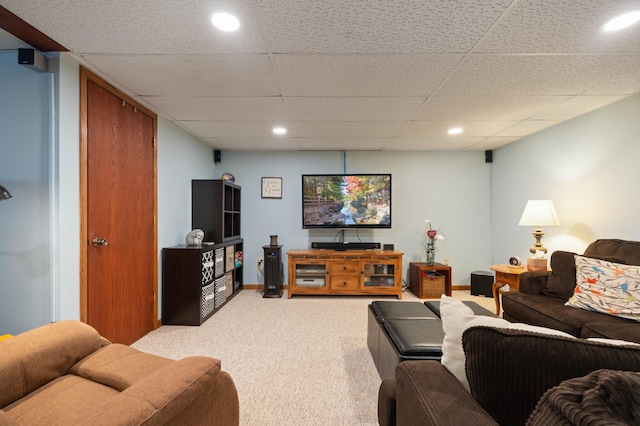 living room with recessed lighting, light colored carpet, a paneled ceiling, and baseboards