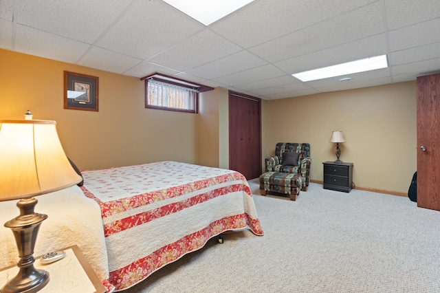 bedroom featuring carpet floors, baseboards, and a paneled ceiling